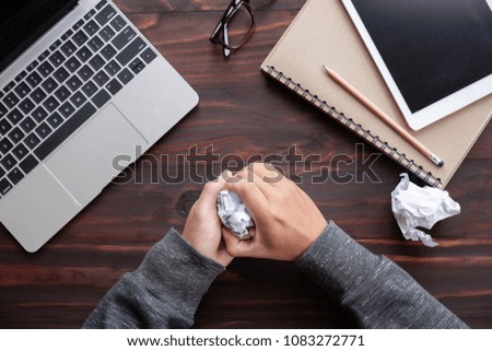 Man hand is crumpled paper at men table in the office trying to come up with the right solution