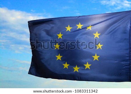 European flag in front of blue sky with clouds