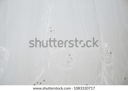 Background of white fabric with a pattern. Fatine with a picture and decoration. Veil of the bride closeup