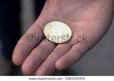 The man stretches a bitcoin, bitcoin in the hand, open palm with bitcoin
