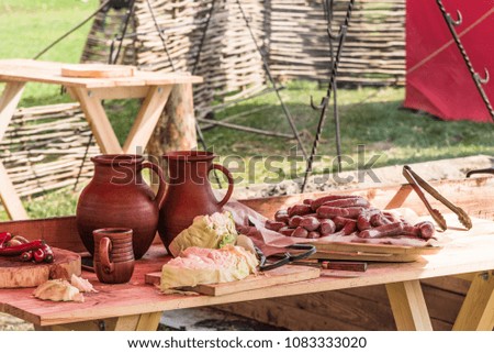 Table for cooking outdoors on a picnic - glazed jugs, vegetables and cooking products on the table