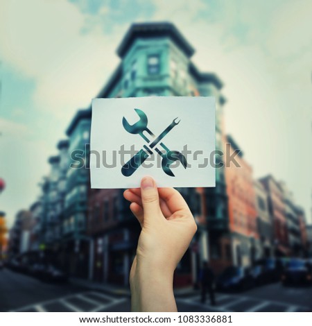 Woman hand holding a paper sheet with wrench and screwdriver tools icon over city buildings background. Bussiness repair concept.