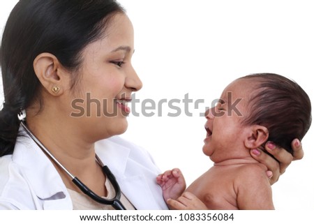 Young doctor woman holding a newborn baby against white background