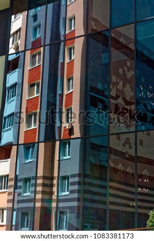 Glass windows reflecting building as detail of modern architecture