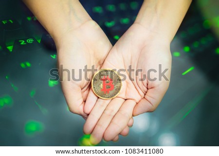 Golden Bitcoin in a woman's hand . Symbol of a new virtual currency .