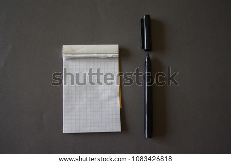 Top view of notebook with pen on dark desk background