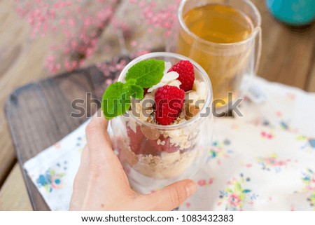 Green tea and muesli with berries and yogurt for breakfast. Healthy food. Vegetarian. A bouquet of flowers in a vase. Text

