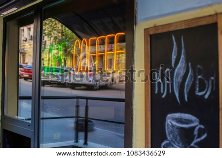 Vape and coffee shop neon sign. Coffee bar window. Writing in Ukrainian: Coffee. Coffee shop in Kiev center.