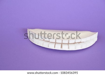 Teeth out of sugar cubes on a colurful background