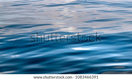Glossy and shining and smooth dark blue ripple background texture, water wave, ocean ripples moving Royalty-Free Stock Photo #1083466391