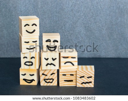 Different emotions drawn on wooden cubes on the dark background.  Royalty-Free Stock Photo #1083483602