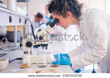 Beautiful young woman scientist in laboratory working. Young female scientist doing some research. Royalty-Free Stock Photo #1083503930