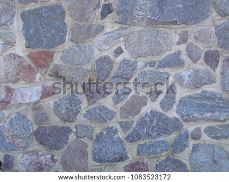 texture, background. The pavement of granite stone. Old cobblestone road pavement texture, grass between stones