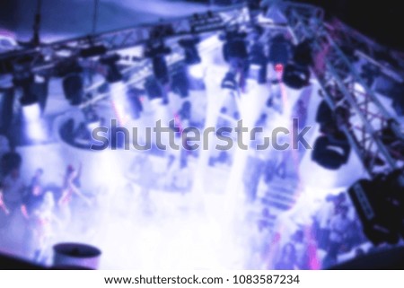 blurred for background Night club dj party people enjoy of music dancing sound with colorful light with Smoke Machine and lights show. Hands up in earth.