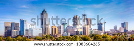 Downtown Atlanta Skyline showing several prominent buildings and hotels under a blue sky. Royalty-Free Stock Photo #1083604265
