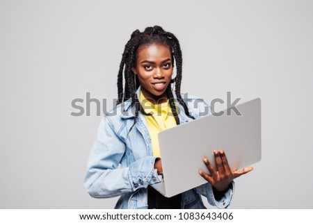 Portrait of smiling young afro american woman using laptop isolated over white