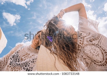 Two girls on the beach loosing hair.