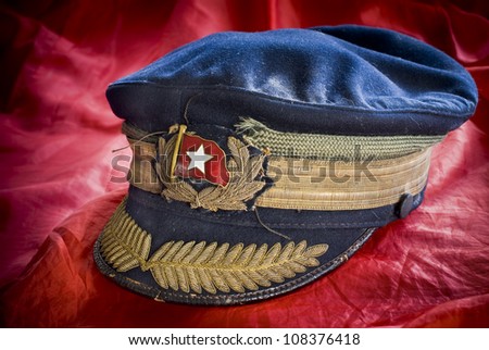 Very old military cap, possibly russian, on red background