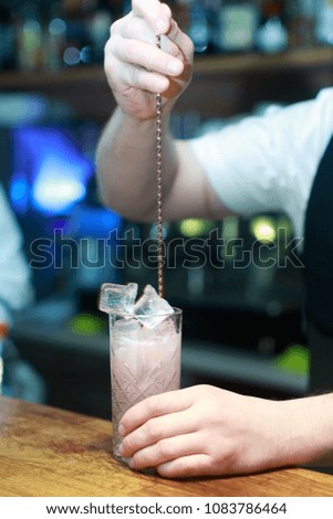Barman makes a cocktail on the bar in the restaurant