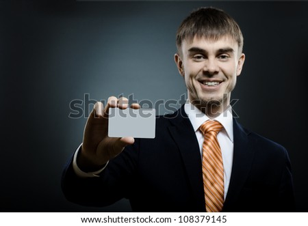 businessman  reach out on camera and show credit card or visiting card, smile