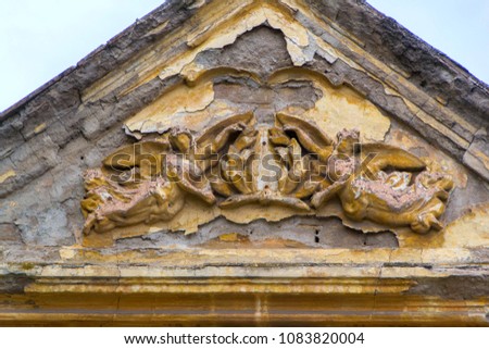 Sculpture of two angels with a coat of arms on a very old house