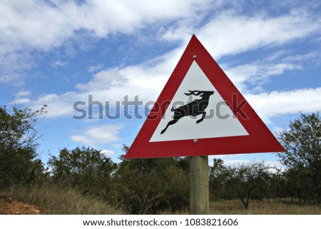A game crossing sign with a silhouette of a kudu in a South African game reserve.