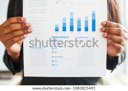 Trade concept. Hands holding documents with graphs and trade details Royalty-Free Stock Photo #1083825491