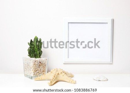 Succulents or cactus in concrete pots over white background on the shelf and mock up frame photo