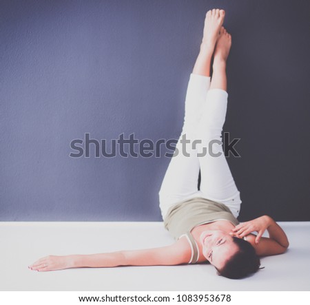 Young woman lying on the floor with legs up