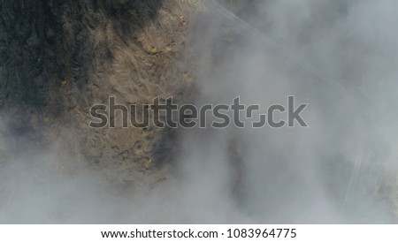 Aerial top down picture of volcanic landscape beautiful road and clouds also showing cooled down lava flows and in between the fertile soil with vegetation on landscape road leads to Mount Etna
