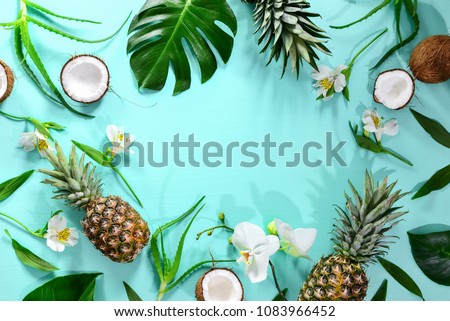 Summer tropical background with a space for a text, various fruits, green leaves and flowers arranged in a way that light shadows are fallen on the background surface, helping to keep some sum Royalty-Free Stock Photo #1083966452