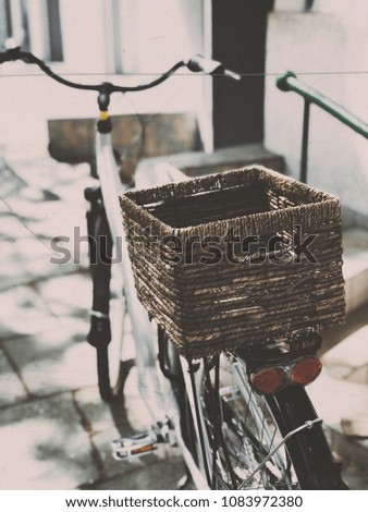 Stylish city bicycle with wickered basket on street