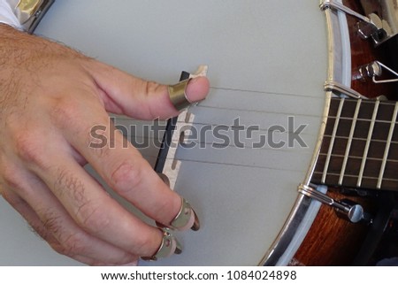 hand with banjo picks and strings in detail, musical instrument close up, music concept