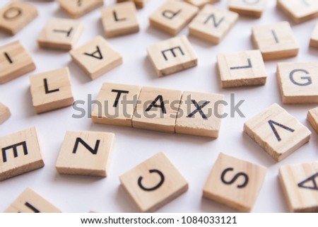 Alphabet letter wooden blocks tiles. Tax text on white paper background