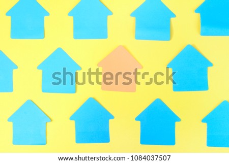Turquoise stickers in the form of a house on a yellow background. In the center, the empty sticker is pale orange. Bright beautiful layout, mock up. Photo from the top.