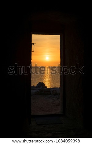 Beautiful sunset at Adriatic Sea in Razanj Croatia Europe. Open door of small stone church building. Nice colorful warm spring evening at the ocean. Calm, peaceful, abstract background image. 