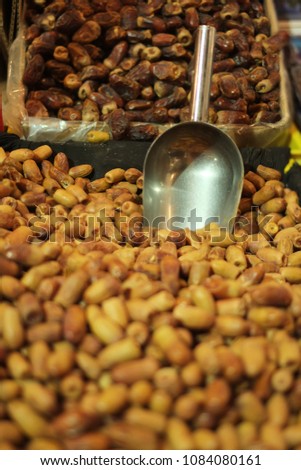 Commercial Quantity of Dates for sale a with scoop in  a market stand.