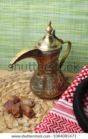 Dates fruits and a traditional  Qahwa with Gulf coffee usually served during breaking the fast of Ramadan. Beside it is the traditional Bedouin headdres used in Middle East countries esp Saudi Arabia.