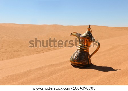 A Dallah traiditonal pot on a red sand desert 