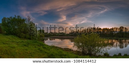 spring evening landscape after a sunset. a beautiful panoramic view from the high hilly coast of the river