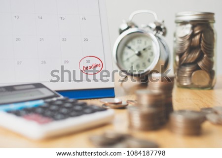 Tax payment season and finance debt collection deadline concept. Money coins stack, calendar, calculator and clock Royalty-Free Stock Photo #1084187798