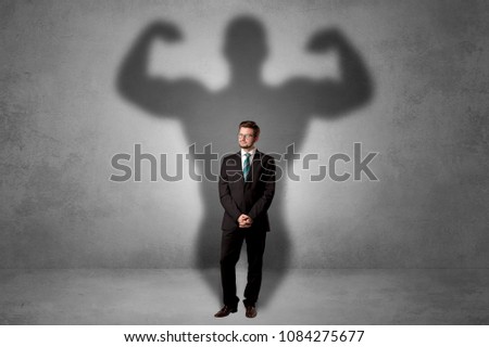 Lovely serious businessman standing with a muscular powerful shadow behind his back
