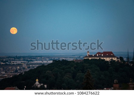 Evening view of Supermoon rising over old town. Night shot of Brno cityscape, Czech Republic.