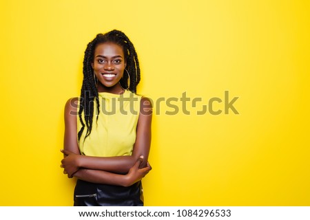 Beauty portrait of young african american girl posing on yellow background, looking at camera. Royalty-Free Stock Photo #1084296533