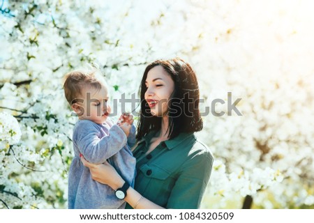 Happy loving family mom and child girl kissing and hugging outdoor in blossom park. Mother day, Relationship Love Values Tenderness Lifestyle