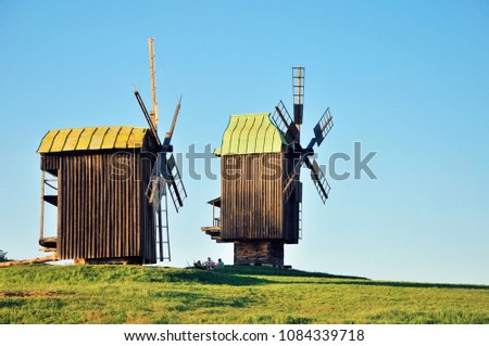 Two old wooden windmill on the field. Pirogovo Village, Kiev, Ukraine Royalty-Free Stock Photo #1084339718