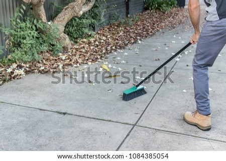 tidying up the front yard with broom