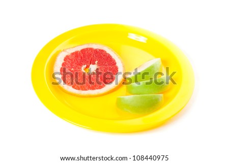 A picture of piece of grapefruit and apple on the yellow plate