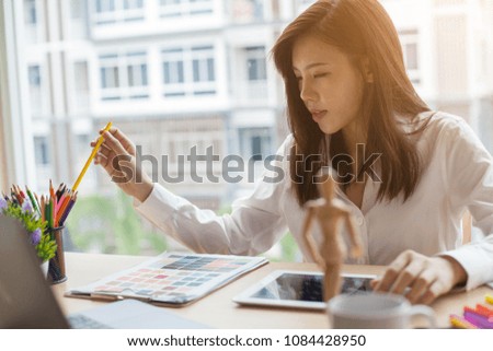 Woman graphic designer working on computer while sitting at the table
