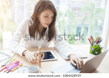 Woman graphic designer working on computer while sitting at the table